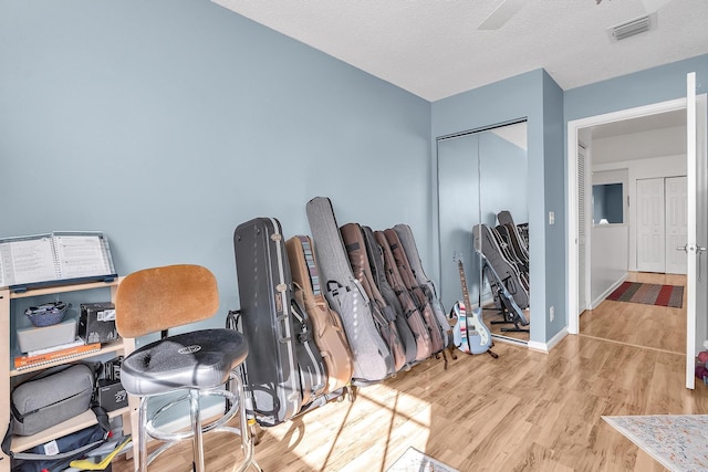 office with light hardwood / wood-style flooring and a textured ceiling