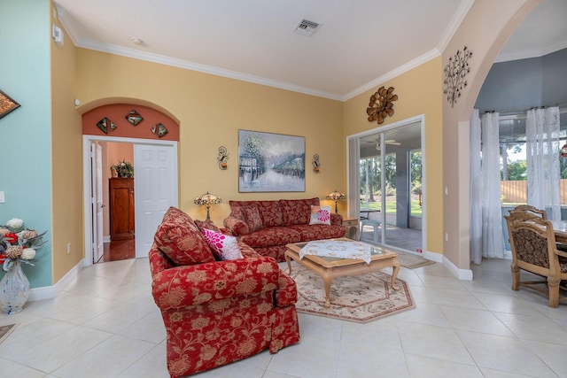 living area with arched walkways, crown molding, light tile patterned floors, visible vents, and baseboards