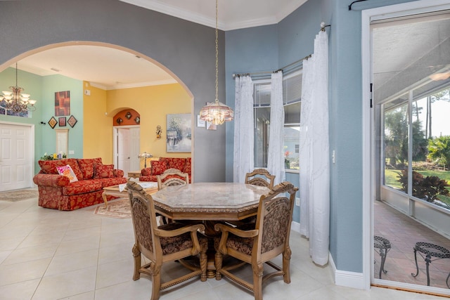 dining room featuring ornamental molding, arched walkways, and a chandelier