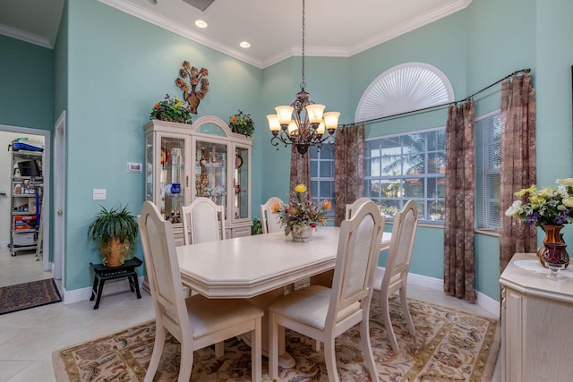 dining space with a chandelier, light tile patterned flooring, a towering ceiling, baseboards, and crown molding