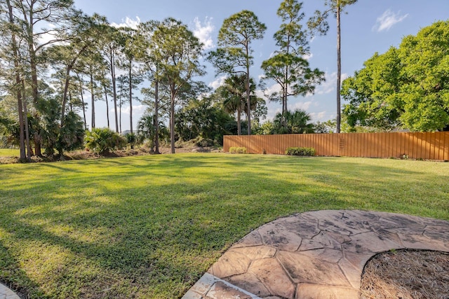 view of yard featuring fence and a patio