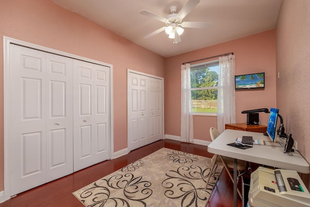 office area featuring dark wood-type flooring, a ceiling fan, and baseboards