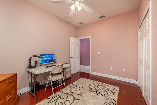 office area with ceiling fan, dark wood-style flooring, visible vents, and baseboards