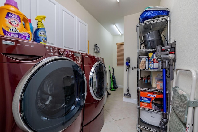 laundry room with washing machine and dryer, baseboards, and light tile patterned flooring