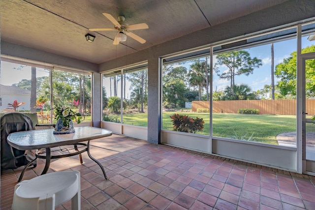 sunroom / solarium featuring a healthy amount of sunlight and ceiling fan