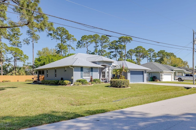 single story home featuring an attached garage, driveway, metal roof, and a front yard