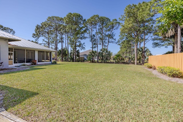 view of yard with fence and a sunroom