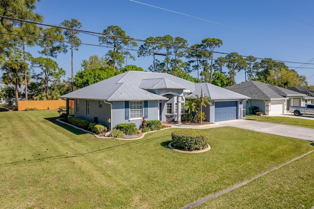 single story home featuring concrete driveway, metal roof, an attached garage, a front lawn, and stucco siding