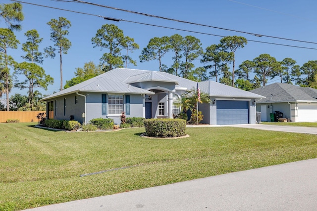 ranch-style home with stucco siding, concrete driveway, an attached garage, a front yard, and metal roof