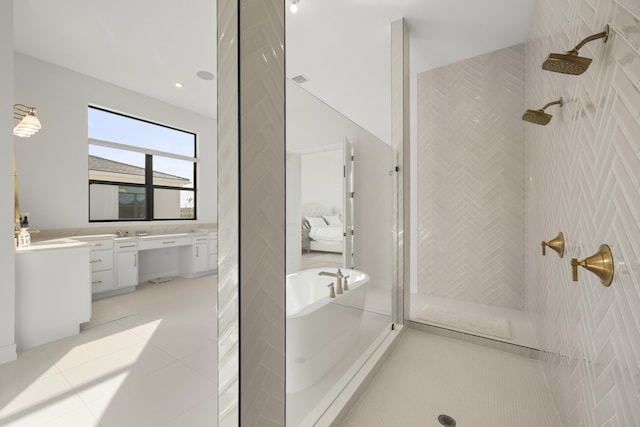 full bathroom featuring a soaking tub, tile patterned floors, a tile shower, vanity, and tile walls