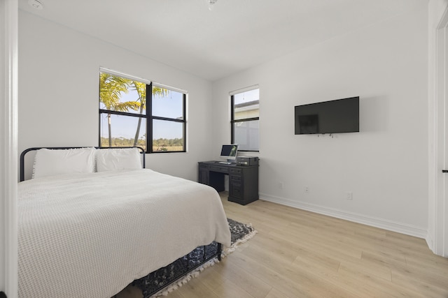 bedroom with light wood-style floors and baseboards