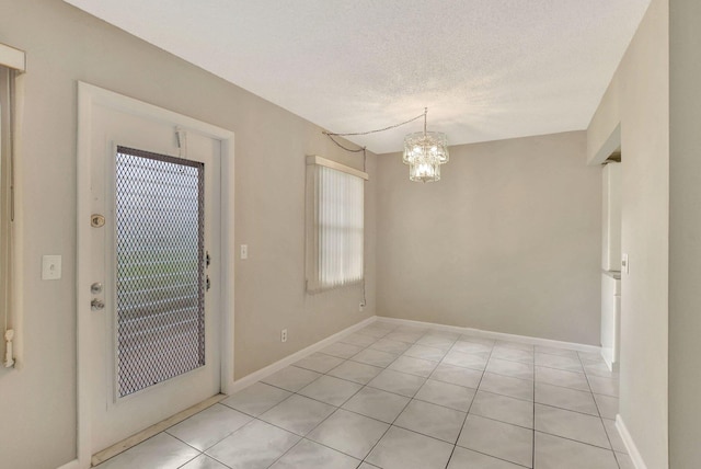 interior space with an inviting chandelier, light tile patterned flooring, a textured ceiling, and a wealth of natural light