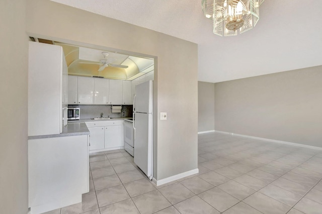 kitchen featuring white cabinetry, tasteful backsplash, light tile patterned floors, ceiling fan, and white appliances