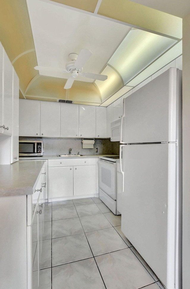 kitchen featuring sink, white appliances, ceiling fan, tasteful backsplash, and white cabinets