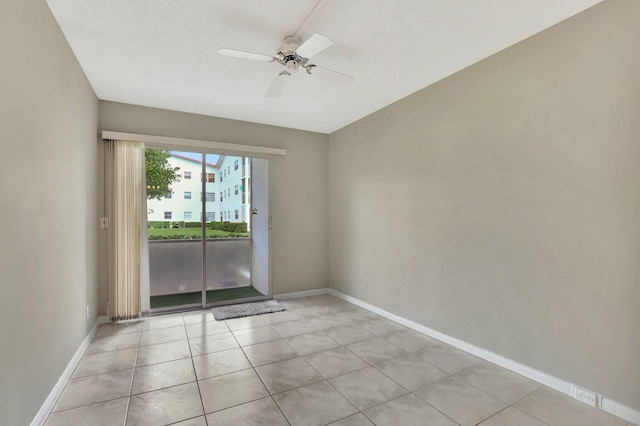 spare room featuring light tile patterned floors, a textured ceiling, and ceiling fan