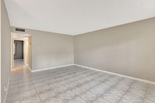 unfurnished room with a textured ceiling