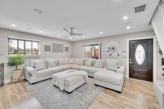 living room with a wealth of natural light, ceiling fan, and light hardwood / wood-style flooring