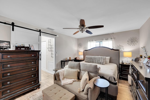 bedroom with ceiling fan and a barn door