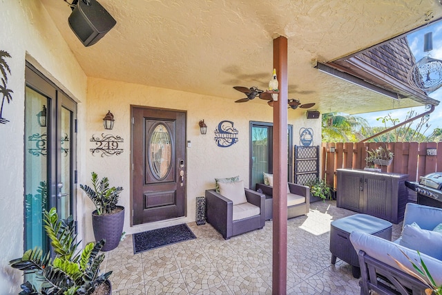 view of exterior entry featuring an outdoor living space, a patio area, and ceiling fan