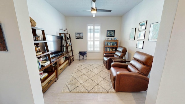 living room with a textured ceiling and ceiling fan