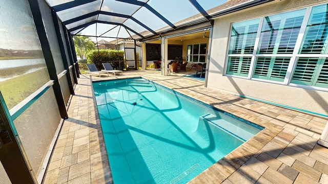 view of swimming pool featuring a patio area and glass enclosure