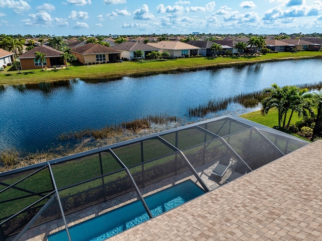 view of swimming pool with a water view, a lanai, and a lawn