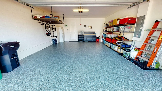 garage featuring white refrigerator, a garage door opener, and electric panel