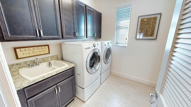 washroom featuring cabinets, sink, and independent washer and dryer