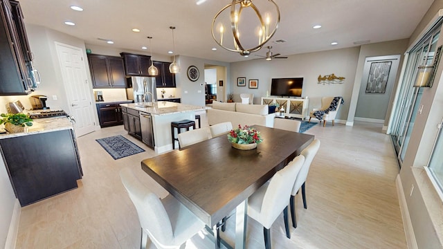 dining area with sink and ceiling fan with notable chandelier