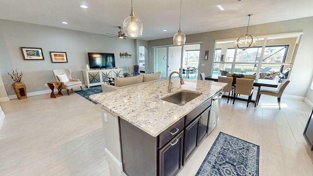 kitchen with a center island with sink, a healthy amount of sunlight, sink, and pendant lighting