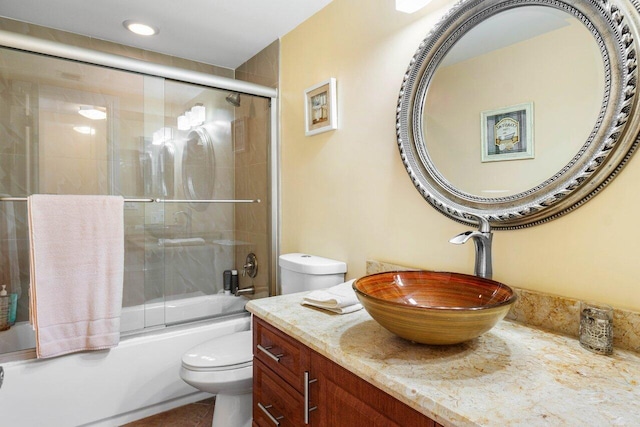 full bathroom with vanity, shower / bath combination with glass door, and toilet