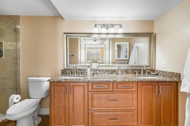 bathroom with vanity, a shower with shower door, and toilet