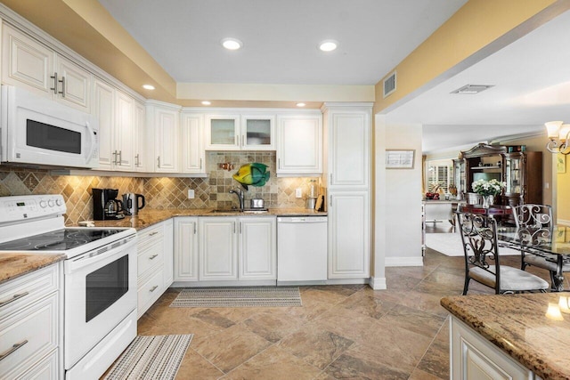 kitchen with white cabinetry, light stone counters, and white appliances