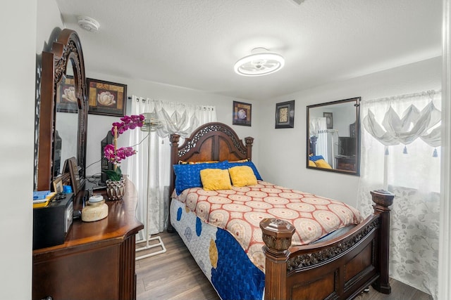 bedroom featuring dark wood-type flooring and a textured ceiling