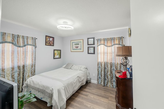 bedroom featuring hardwood / wood-style floors and a textured ceiling