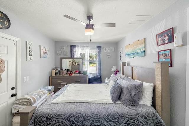 bedroom with ceiling fan and a textured ceiling