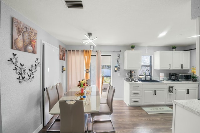 dining room with dark wood-type flooring, sink, and a textured ceiling