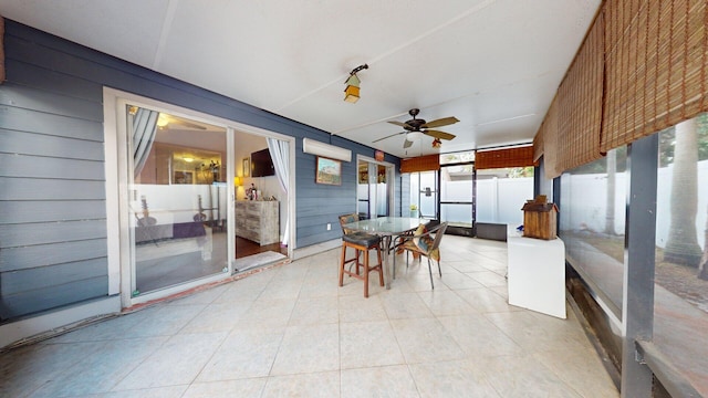 unfurnished sunroom featuring ceiling fan