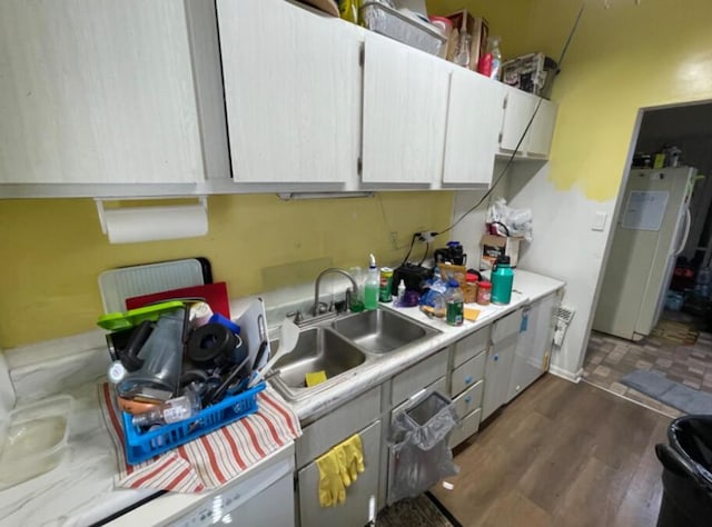 kitchen featuring white cabinetry, sink, dark wood-type flooring, and refrigerator