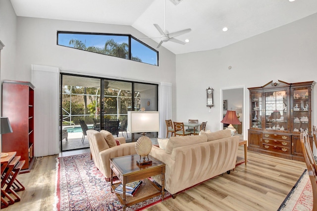 living room featuring ceiling fan, high vaulted ceiling, and light wood-type flooring