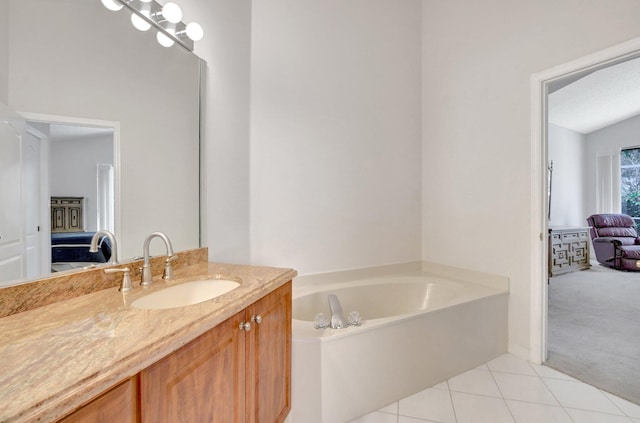 bathroom featuring vanity, a washtub, and tile patterned floors