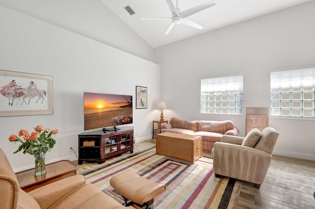 living room featuring hardwood / wood-style flooring, ceiling fan, and high vaulted ceiling