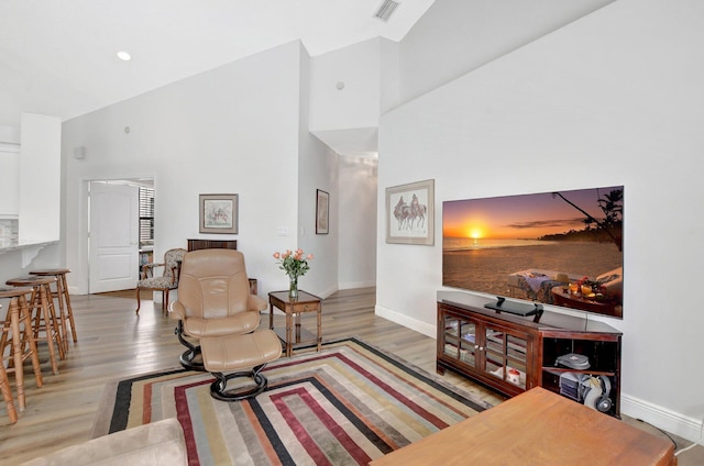 living room featuring wood-type flooring and a towering ceiling