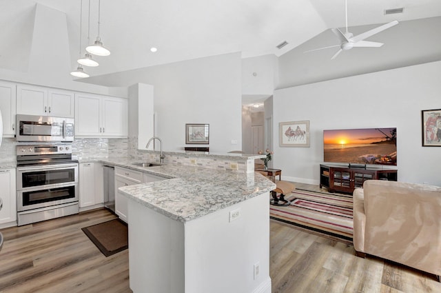 kitchen with pendant lighting, sink, white cabinetry, stainless steel appliances, and kitchen peninsula