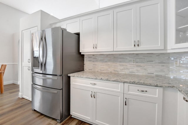 kitchen with white cabinetry, stainless steel fridge with ice dispenser, and decorative backsplash