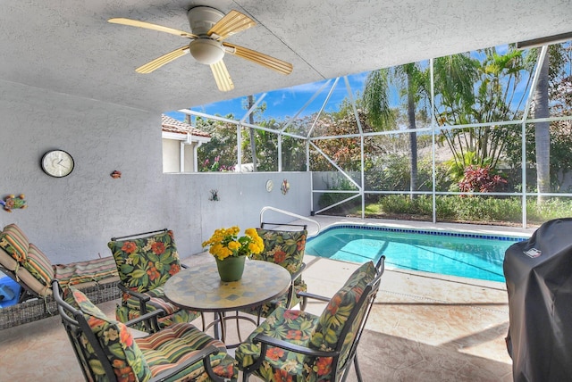 view of swimming pool featuring ceiling fan, a grill, a lanai, and a patio area