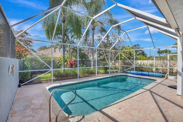 view of swimming pool featuring a patio area and glass enclosure