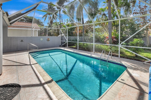 view of swimming pool featuring a patio and a lanai