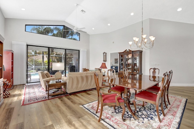 dining area featuring a notable chandelier, high vaulted ceiling, and light wood-type flooring