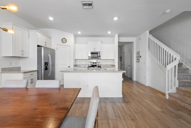 kitchen featuring white cabinetry, sink, light hardwood / wood-style flooring, and stainless steel appliances